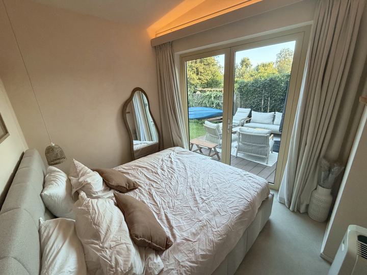 Slaapkamer met tweepersoonsbed en deuren naar het terras