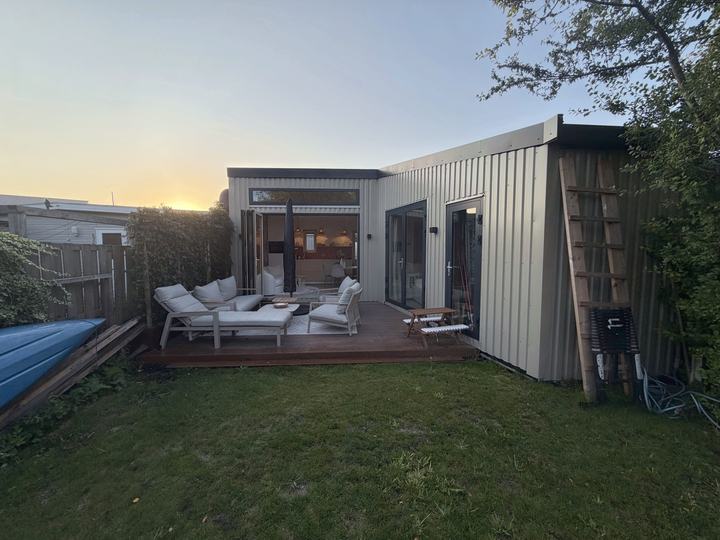 Het huis en de tuin bij zonsondergang